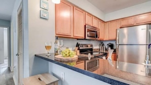 Una cocina moderna con armarios de madera, electrodomésticos de acero inoxidable y encimera de granito.