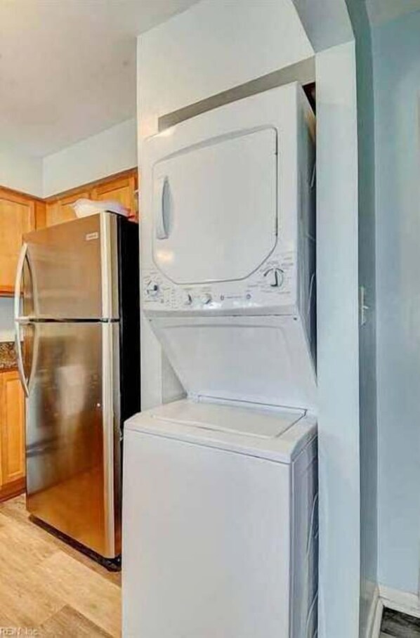 A compact kitchen with a stainless steel refrigerator, a built-in oven, and a dishwasher.