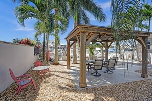 Relax in the shaded patio area with comfortable seating and dining options.