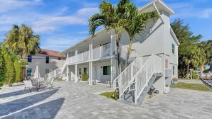 A two-story building with a covered patio area, outdoor seating, and a staircase leading to the upper level.