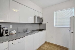 Een koffiezetapparaat/waterkoker, kookgerei, borden en bestek