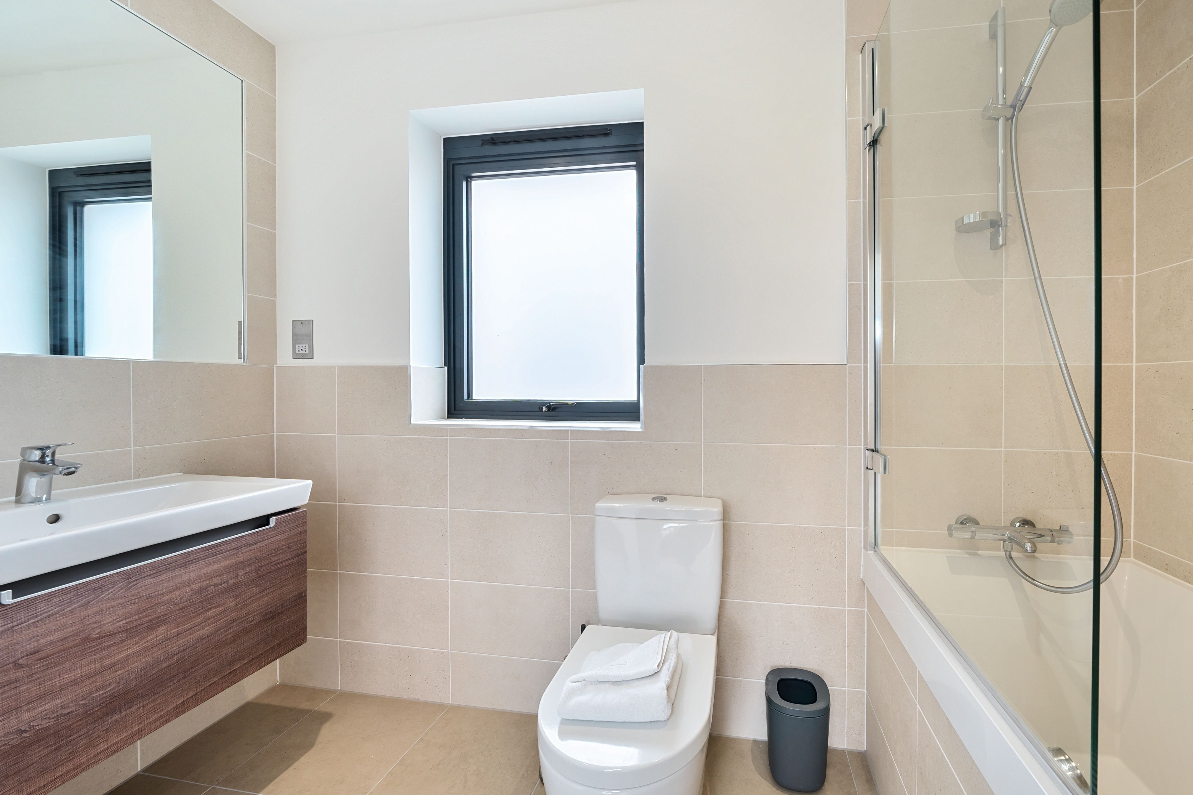 Un bagno moderno con un water, un lavandino e una doccia.