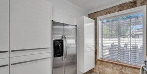 Enjoy cooking in this well-equipped kitchen with a refrigerator, ice and water dispenser, and ample cabinetry.