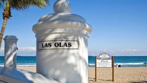 A beach scene with a large white structure labeled "LAS OLAS" and a sign reading "Welcome to Fort Lauderdale Beach." - Urban Escape 1BR Near Las Olas (Fort Lauderdale)