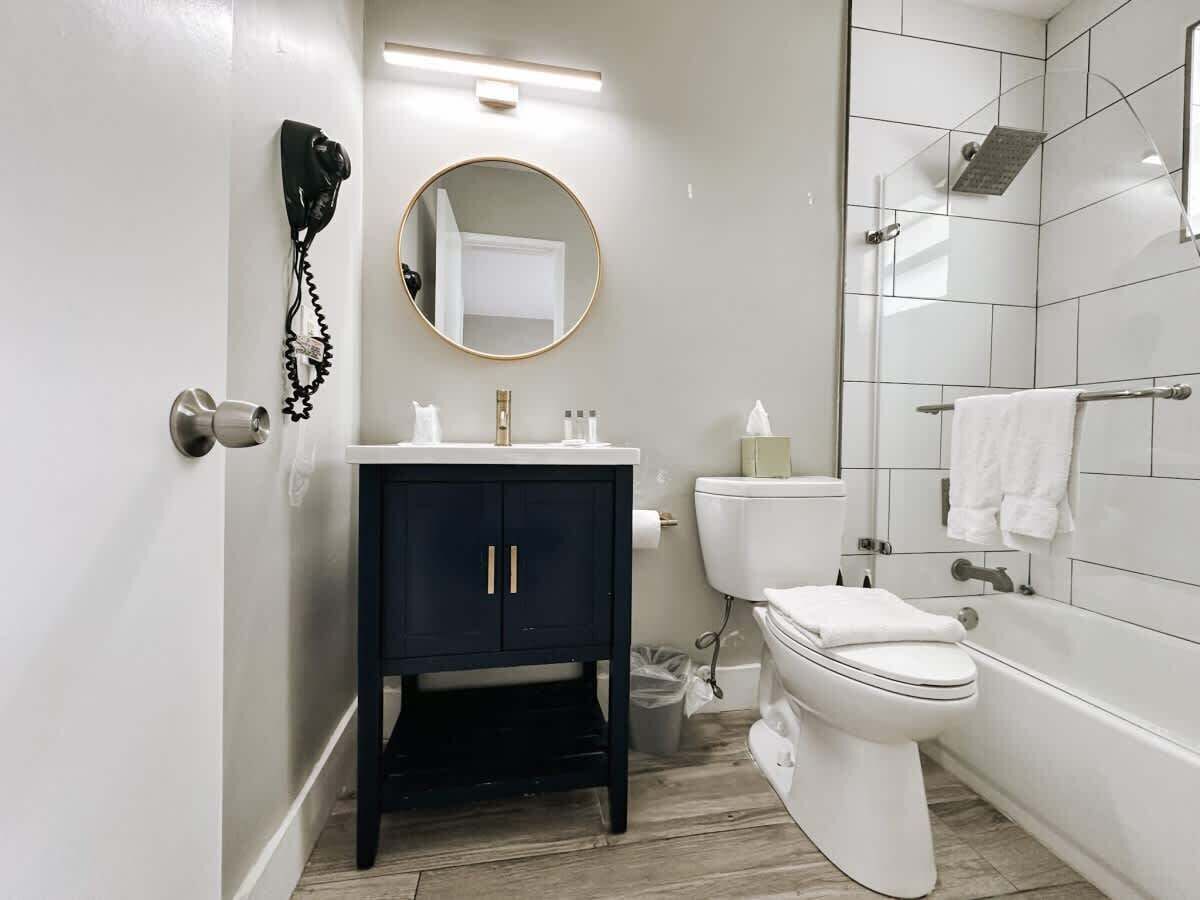 A modern bathroom with a toilet, sink, and shower.