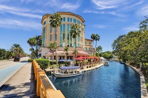Un hotel con vista sul canale, un pontile per barche e posti a sedere all'aperto con ombrelloni.