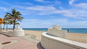 Un paseo marítimo bordeado de palmeras con una vista despejada del océano.