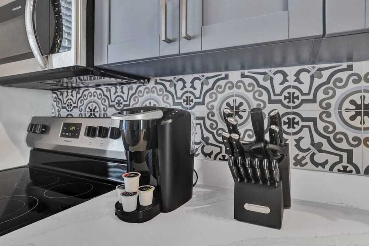 A kitchen with a coffee maker, a knife block, and a microwave.