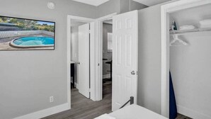 Habitación con vistas a una piscina, una puerta blanca y un baño con tendedero para toallas.