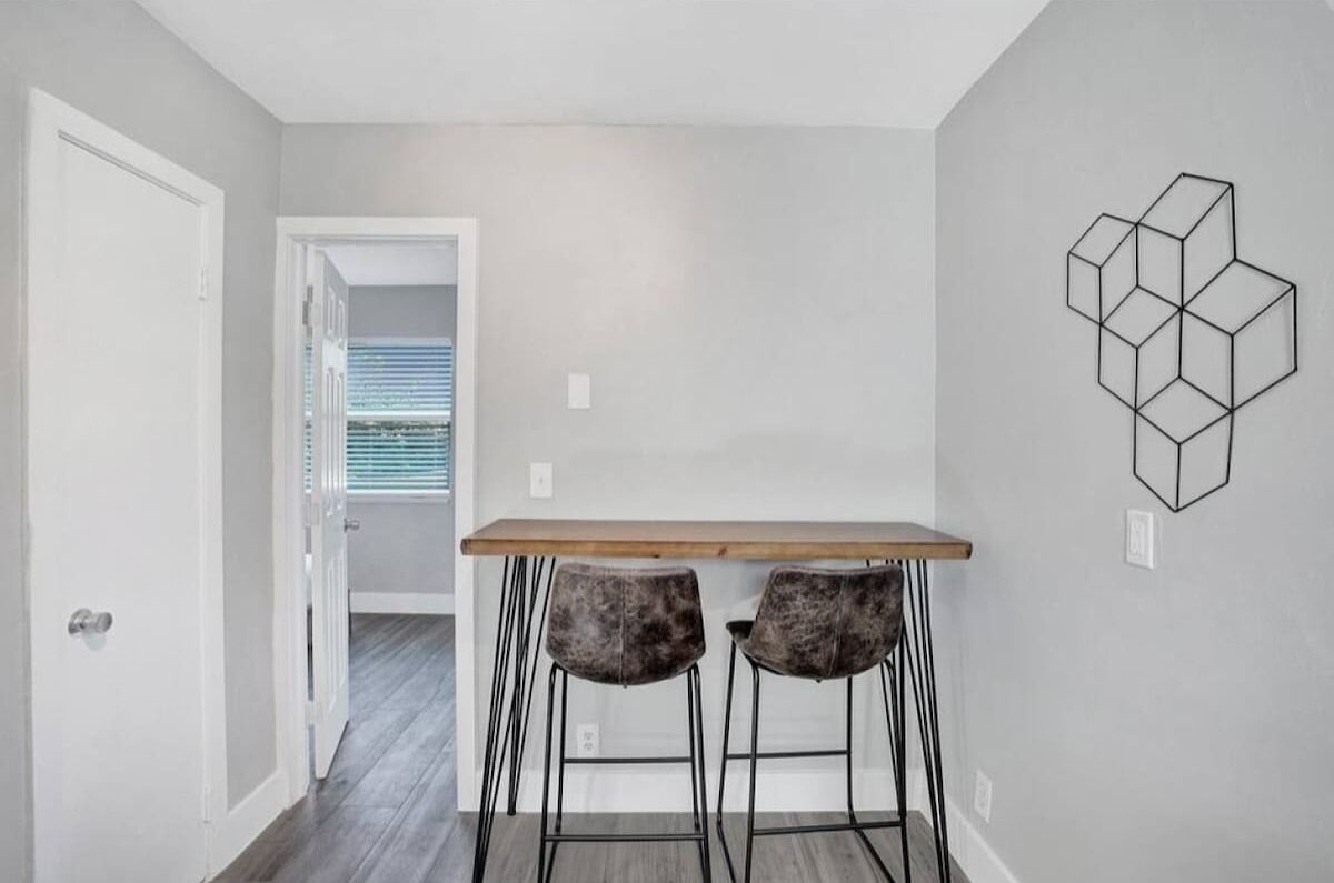 A modern kitchen with a wooden countertop and two bar stools.