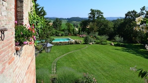 A well-maintained garden with a swimming pool, a brick wall, and a clear view of the surrounding landscape. - Country House With Private Pool (Toscane)