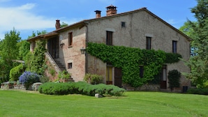 A stone building with a sloped roof, ivy-covered walls, and a well-maintained lawn. - Country House With Private Pool (Toscane)