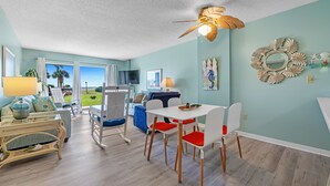 A spacious living room with a dining area, a ceiling fan, and a view of the outdoors. - Gulf Shores Plantation-Palms 6109 (Gulf Shores)