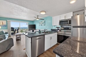 A modern kitchen with stainless steel appliances, a dishwasher, and a large island with a sink.