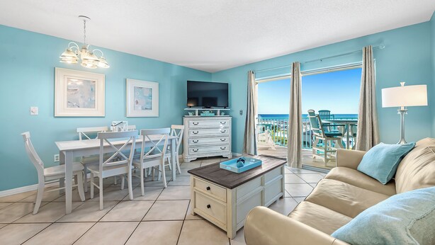 A living room with a dining area, a TV, and a view of the ocean. - Gulf Shores Plantation-Palms 6406 (Gulf Shores)