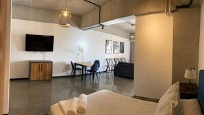 Ein modernes Hotelzimmer mit einem großen Bett, einem Schreibtisch und einer Essecke.