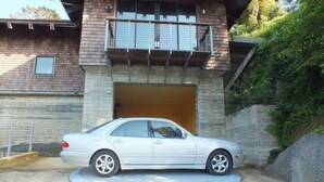 A white car parked in front of a house with a balcony and a garage. - Mendocino Coast Hideaway (Albion)
