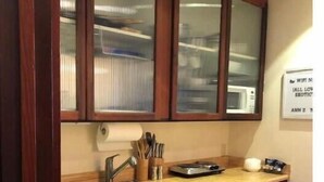 A kitchen with wooden cabinets, a stainless steel sink, and a countertop with kitchen utensils. - Mendocino Coast Hideaway (Albion)