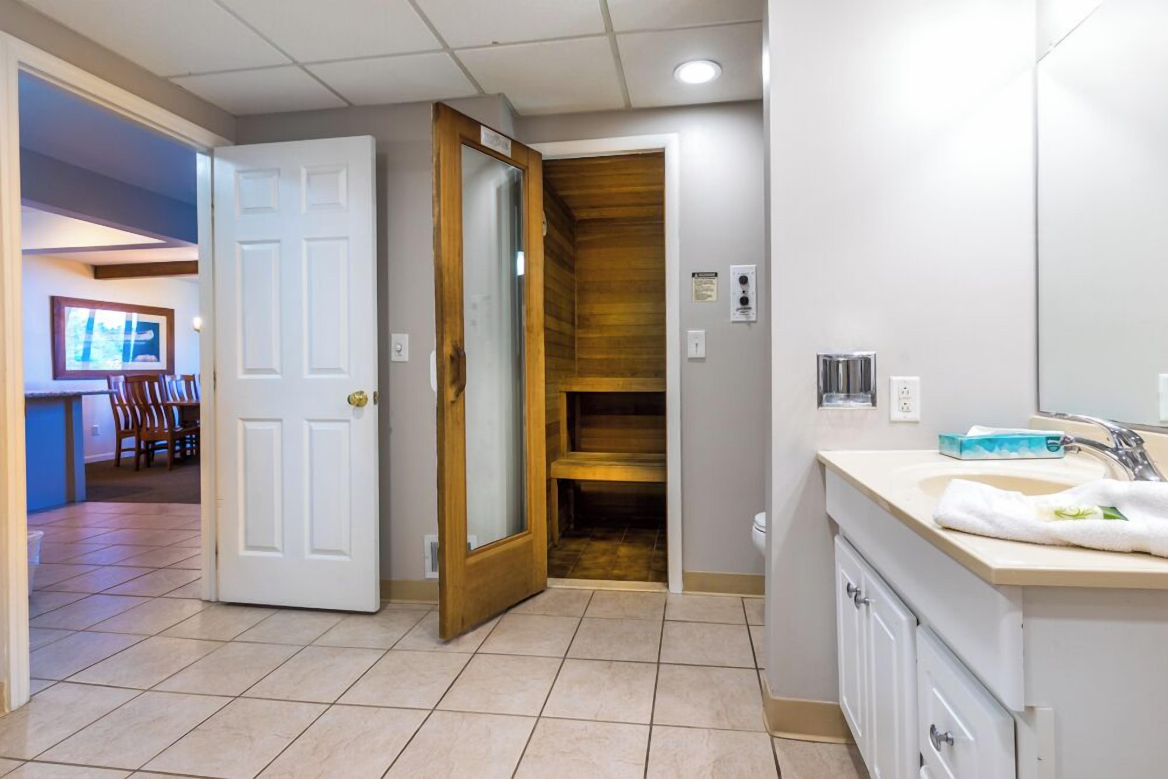 Une salle de bain avec un lavabo, un miroir et un mur recouvert de panneaux en bois.