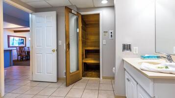 Une salle de bain avec un lavabo, un miroir et un mur recouvert de panneaux en bois.