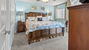 A bedroom with a wooden bed, a ceiling fan, and a window with blinds. - Beautiful 12th Floor Oceanfront Get Away in North Myrtle Beach (North Myrtle Beach)
