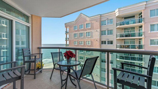 A balcony with a table, chairs, and a potted plant. - Beautiful 12th Floor Oceanfront Get Away in North Myrtle Beach (North Myrtle Beach)