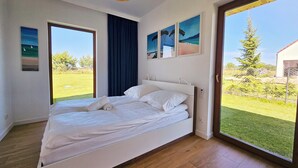 Une chambre avec un grand lit, une fenêtre et une vue sur l’extérieur.