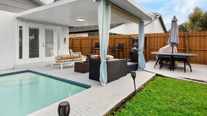 A covered patio with a pool, outdoor furniture, and a wooden fence. - Gulf Coast Get-Away! Heated pool, sleeps 10! 69th (Largo)