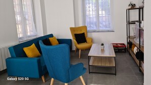Ein modernes Wohnzimmer mit einem blauen Sofa, einem gelben Sessel und einem Couchtisch.