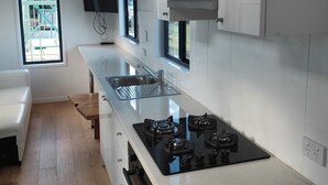 Une cuisine moderne avec des armoires blanches, une cuisinière noire et une grande fenêtre.
