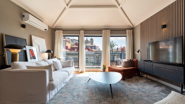 A modern living room with a sofa, a coffee table, and a TV.