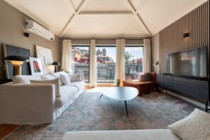 Un salon moderne avec un canapé, une table basse et un téléviseur.