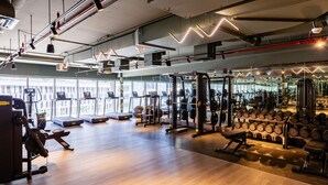 A gym with treadmills, weight machines, and free weights. -  Maison Privee - Exquisite Duplex with Private Patio & Loft Living (Dubai)