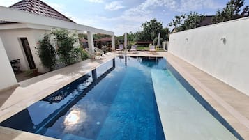 Seasonal outdoor pool, open 9:00 AM to 10:00 AM, pool umbrellas