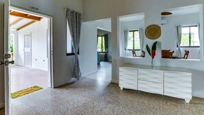 Habitació àmplia amb un tocador blanc, una cistella de veta i vistes a un balcó.