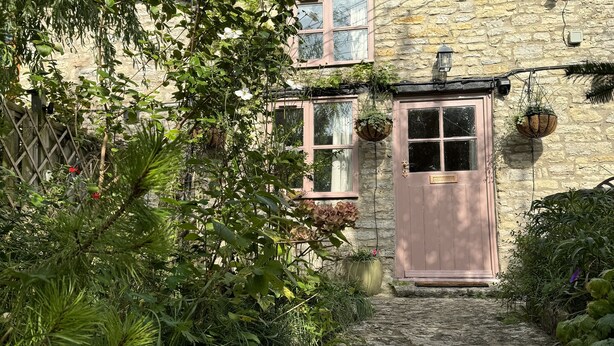 A stone house with a tiled roof, a wooden door, and a cobblestone path leading to it. - 400 year old Grade II listed stone cottage, Pilton; Glastonbury
AA 4* Gold Award (Pilton)