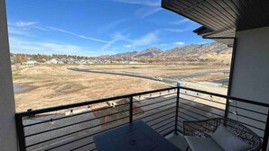 A balcony with a view of a road and mountains.
