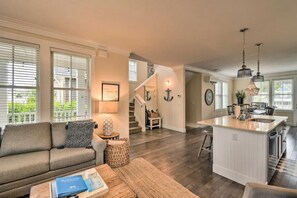A spacious living room with a sofa, coffee table, and a view of the kitchen and dining area. - 'Once Upon A Tide' Seabrook, WA beach home (Pacific Beach)