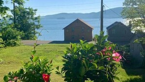A house with a view of a body of water and mountains in the background. - Cozy Hillside Hideaway on Lake Canadarago (Richfield Springs)