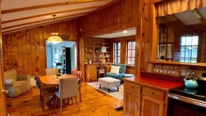 A wooden interior with a dining area, kitchen, and seating space. - Cozy Hillside Hideaway on Lake Canadarago (Richfield Springs)