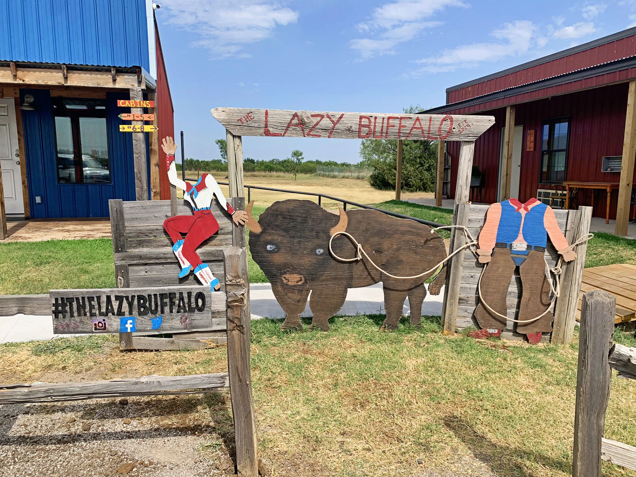 A rustic wooden sign with a cowboy figure and a bison, indicating a themed attraction or establishment.