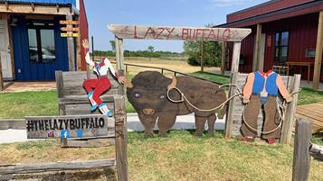A rustic wooden sign with a cowboy figure and a bison, indicating a themed attraction or establishment.