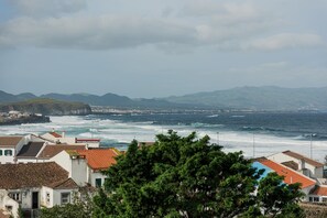 Une ville côtière avec des bâtiments, un littoral rocheux et des vagues qui déferlent sur la plage.