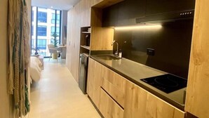 Une cuisine moderne avec des meubles en bois, un évier en acier inoxydable et un four encastré.