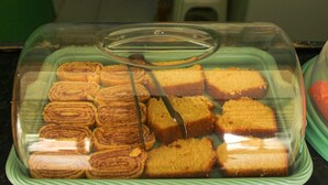A display case with various types of bread, including rolls and slices. - Pousada Barra Grande (Maragogi)
