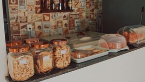 A food display with jars of snacks and a tray of pastries. - Pousada Barra Grande (Maragogi)