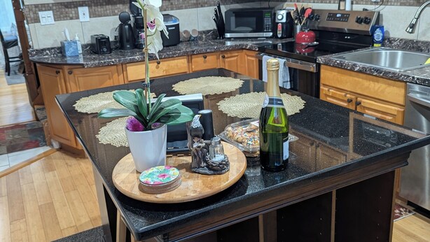 Una cocina con armarios de madera, microondas, tostadora y lavamanos.