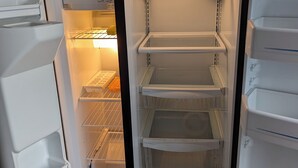 Un refrigerador abierto con varios estantes y un compartimento congelador.