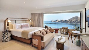 A spacious bedroom with a large bed, a seating area, and a balcony with a view of the sea. - Beach Access!! Beautiful Oceanfront Resort! Room upgrades available!  (Cabo San Lucas)