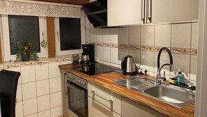 Una cocina equipada con estufa, horno, pileta y cafetera.